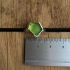 Lime green seaglass ring from Gwenver. Shown next to a ruler, measuring approximately 14mm wide.