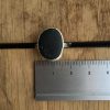 Black sea-pebble ring Swanpool next to a ruler. Stone size is approximately 16mm wide.
