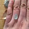 Seafoam seaglass for bespoke order shown on a finger