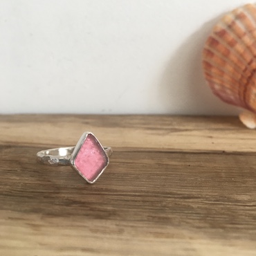 Pink seaglass ring. The seaglass is cut into a kite shape.